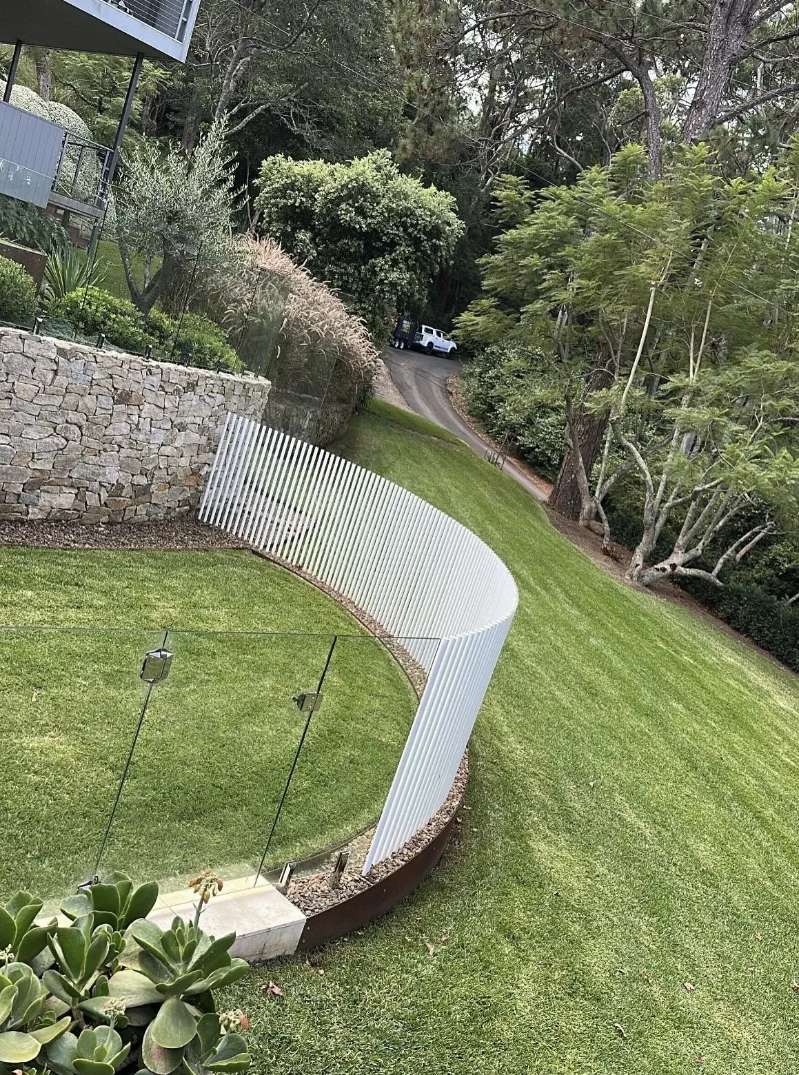 Maintained curved lawn beside garden beds