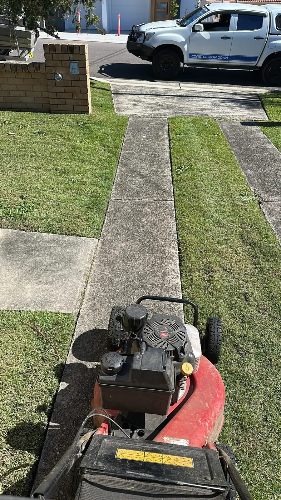 Mower beside a freshly edged residential footpath